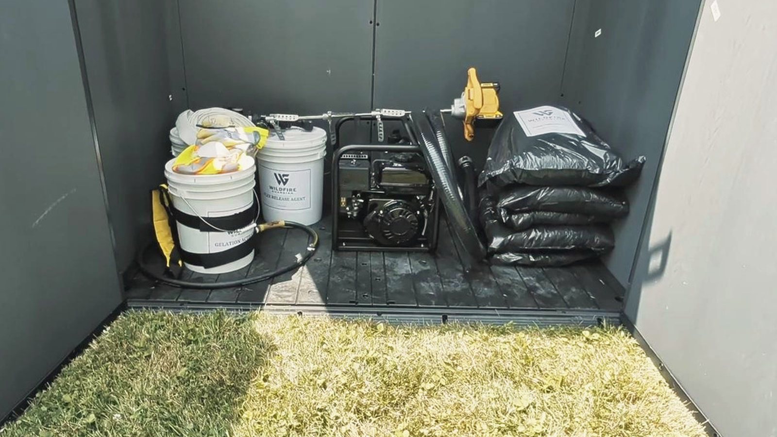 Inside the Wildfire Guardian storage shed: GraphGel powder, activator and release agent pails, the pump and hose