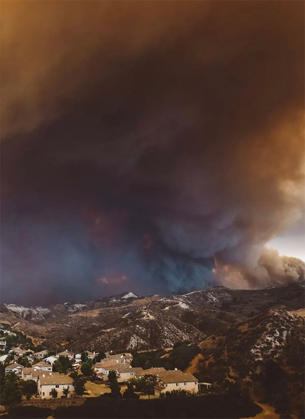 Wildfire smoke approaching residential community, highlighting the need for The Wildfire Guardian™ wildfire protection system.