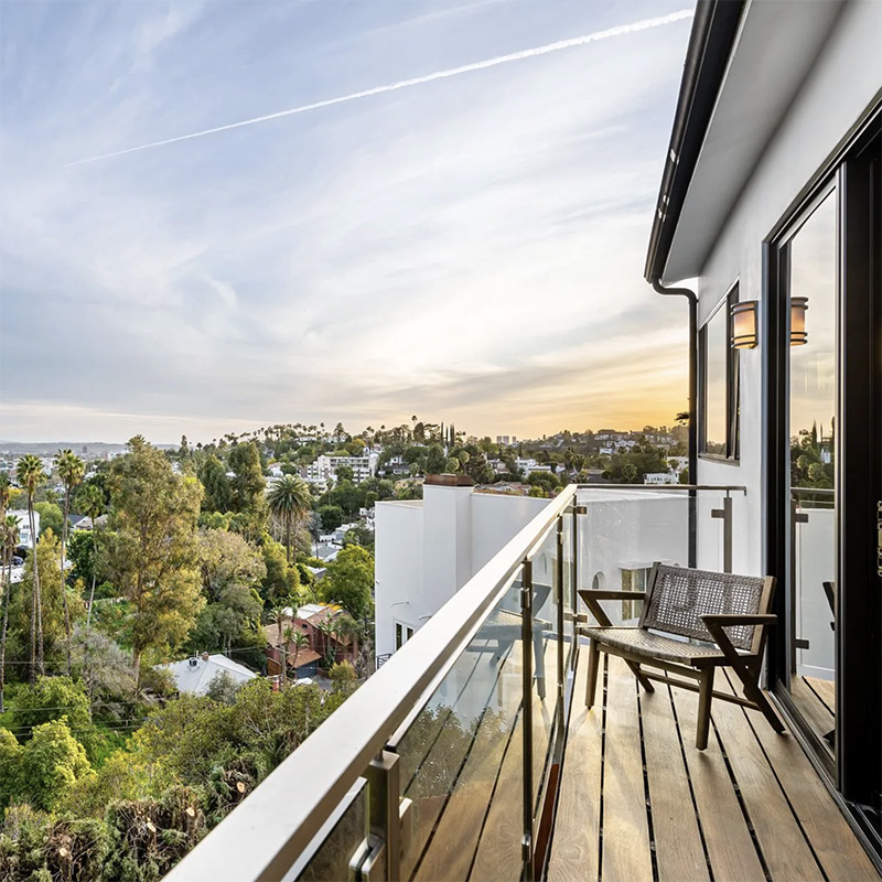 Modern Hollywood hills home with balcony at sunset, protected from wildfire risk Modern Hollywood hills home with balcony at sunset, protected from wildfire risk